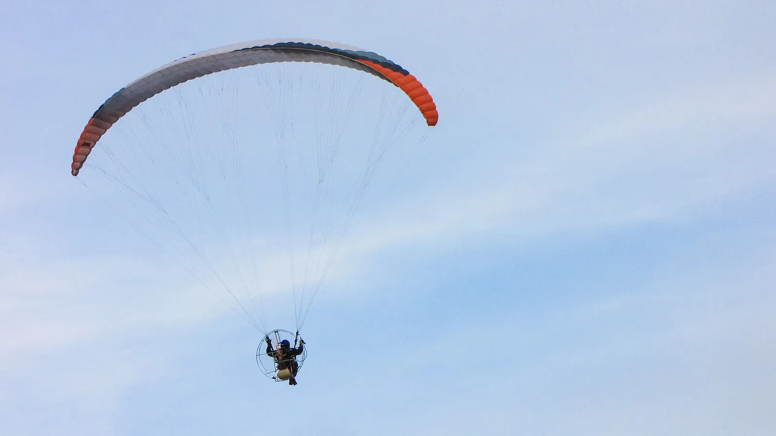 Un paramoteur sous sa voile dans le ciel